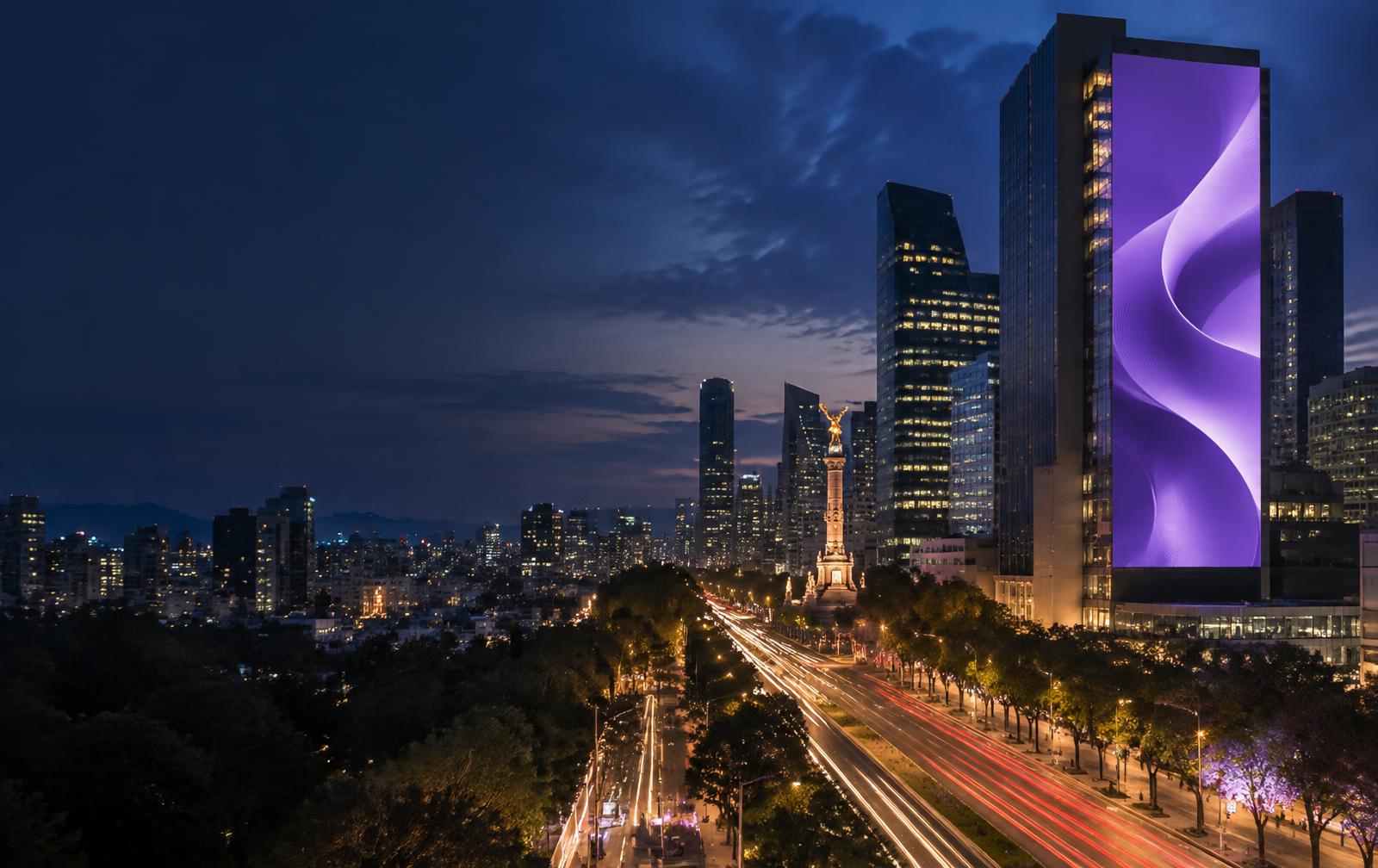 Pantalla digital de gran formato en Paseo de la Reforma en Ciudad de México al anochecer
